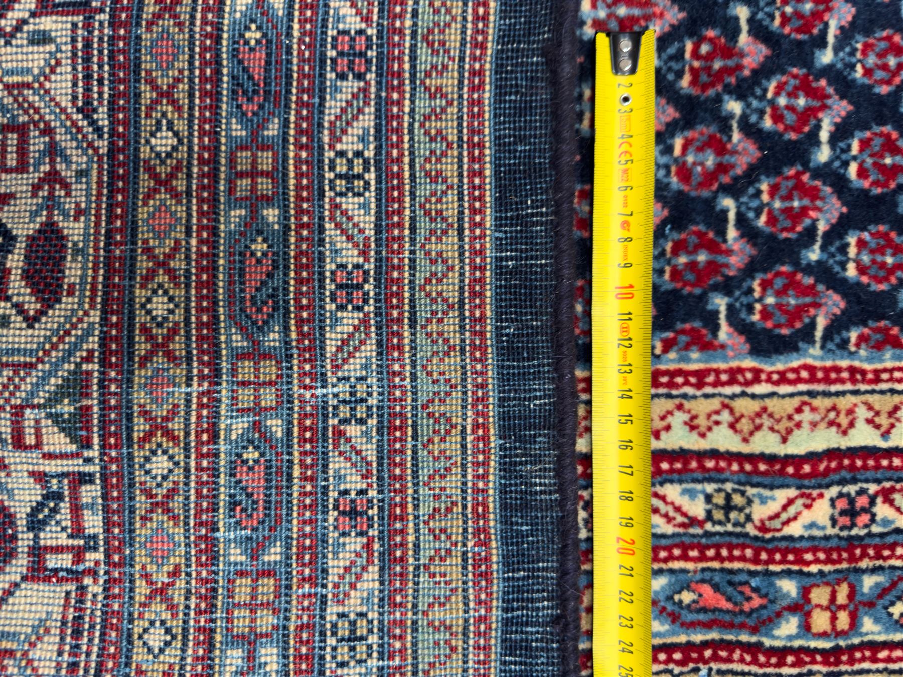 Northwestern Persian Bottehmir hand-knotted carpet, dark indigo field with an all-over design of boteh motifs arranged in diagonal rows, framed by multiple borders, main ivory border with stylized floral sprays between narrow geometric guard stripes, 362cm x 268cm