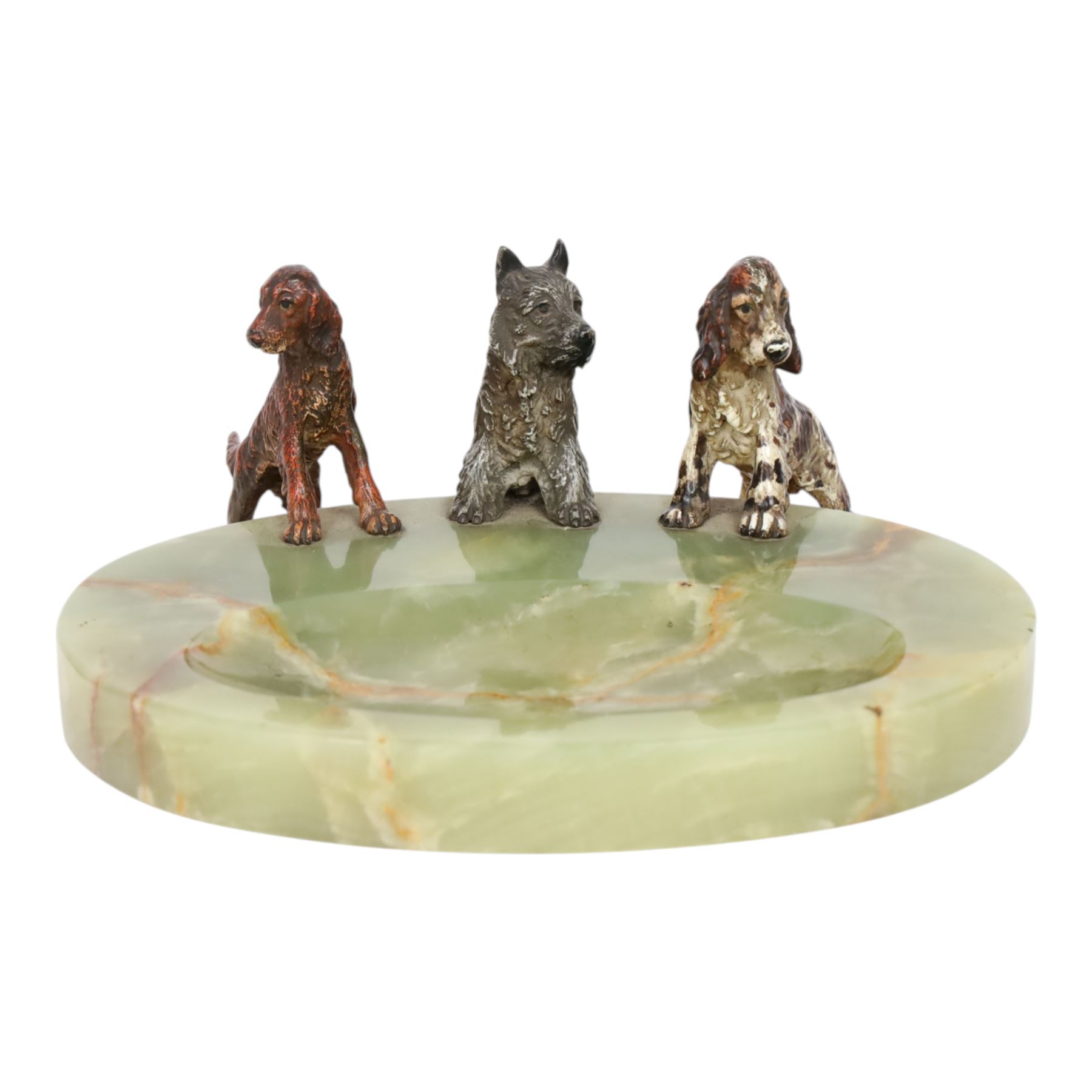 Art Deco ashtray, the oval green onyx tray with oval dished recess, the edge surmounted with three cold painted bronze dogs, comprising Irish Setter, Scottish Terrier and Springer Spaniel, each marked with incised H to base of foot, tray L17cm