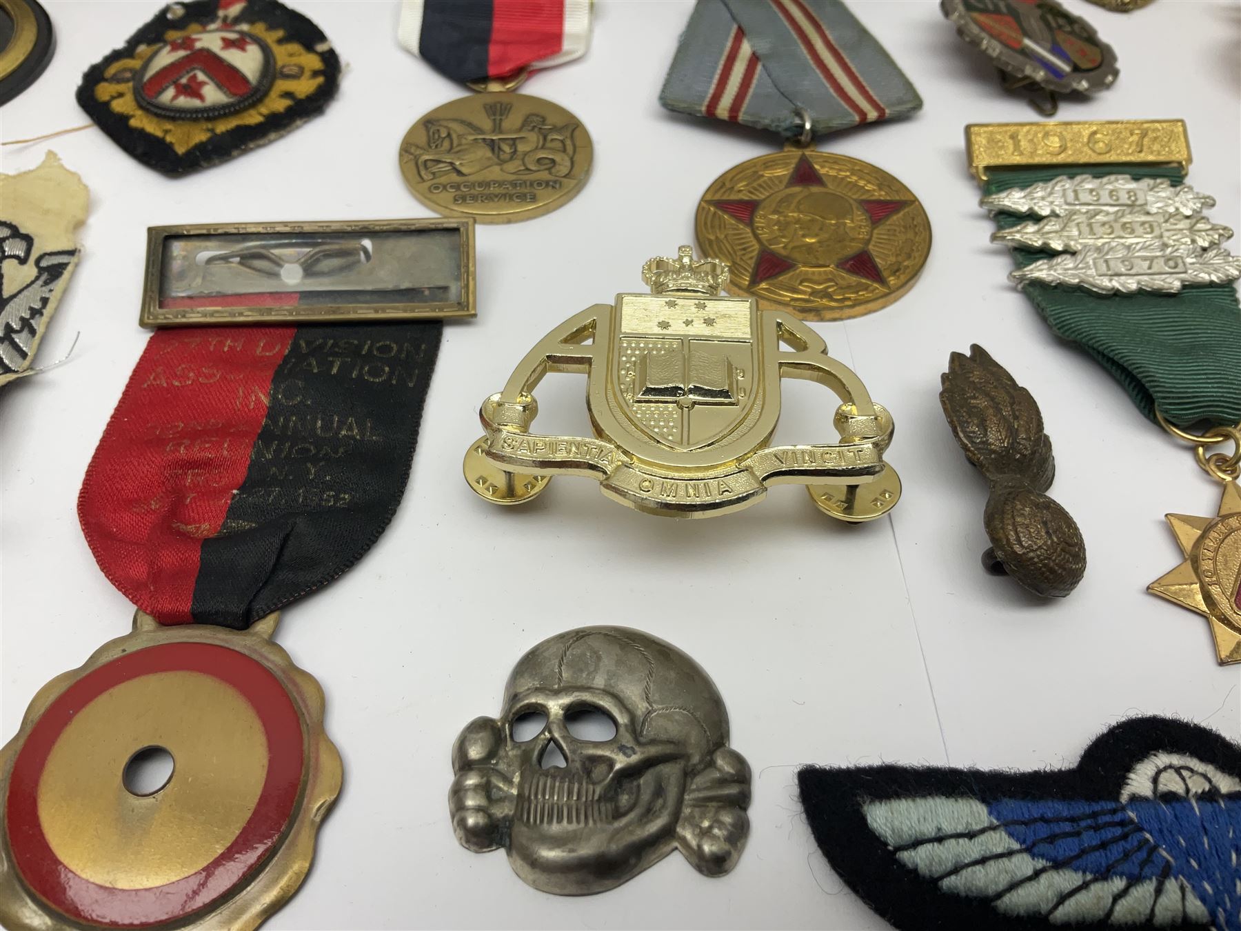 Collection of approximately sixty worldwide medals, metal badges, belt buckles, cloth badges, trench art, brass button stick etc