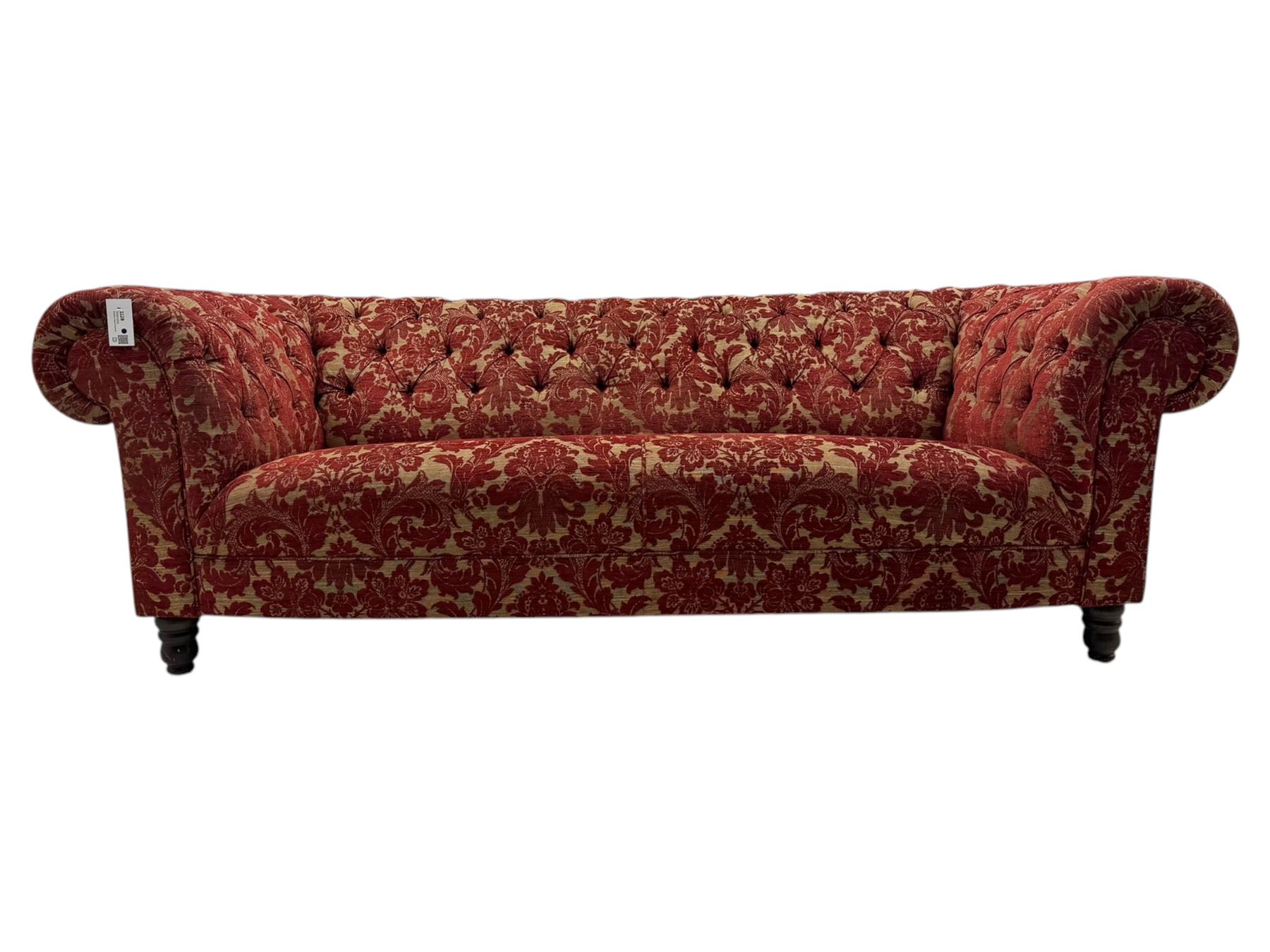 Late 20th century upholstered Chesterfield sofa, in red damask floral fabric, with deep buttoned back and arms, scrolled arms at equal height to back, on turned front supports