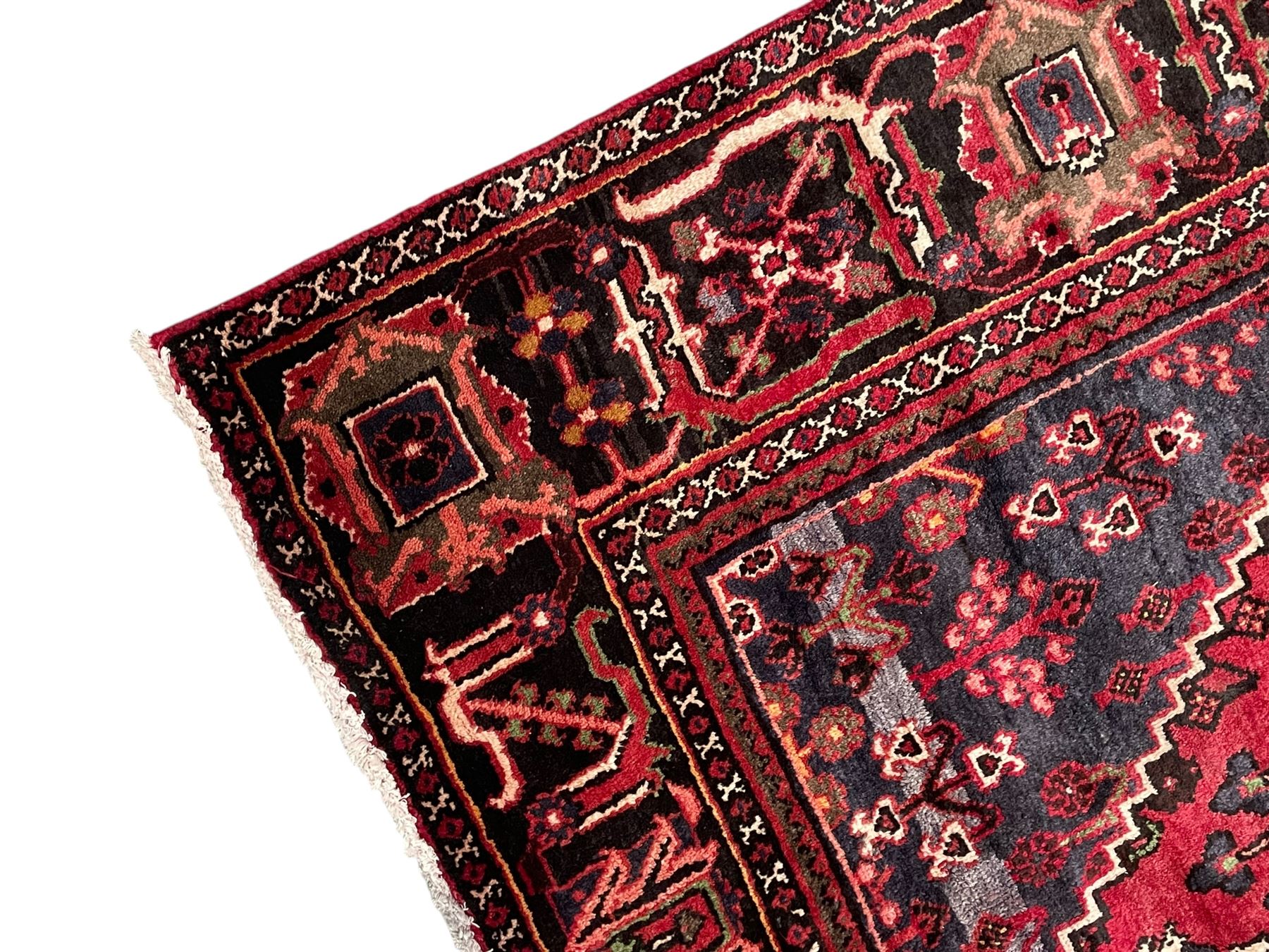 Persian Joshaghan crimson ground rug, stepped lozenge medallion surrounded by repeating foliate lozenge motifs, the border decorated with stylised plant motifs, within geometric guard stripes 