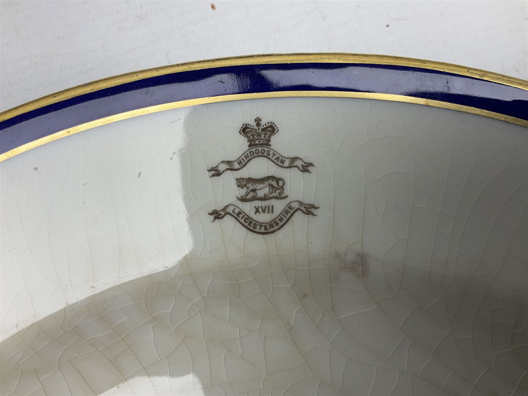 Collection of Regimental dinner wares, Comprising Royal Sussex; two dinner plates, two side plates and a soup bowl, Royal Leicestershire; two dinner plates, East Yorkshire Regiment side plate and Gordon Highlanders side plate, all decorated with the regiment's crests and blue and gilt boarders (9)