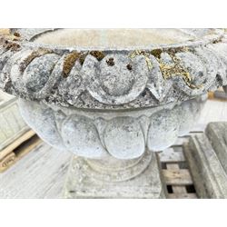 Pair of large weathered Country House Haddonstone garden urns, acanthus carved rim above gadrooned bowl, beaded detailing to the neck, raised on stepped double plinth base
