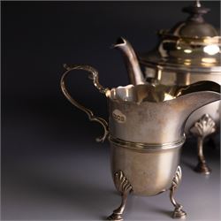 Early 20th century silver three piece bachelor's tea service, comprising teapot, open sucrier and milk jug, all of circular waisted form with shaped rims and upon three stepped feet, the teapot with ebonised wooden handle and finial, hallmarked Wakely & Wheeler, London 1914, teapot height H15cm
