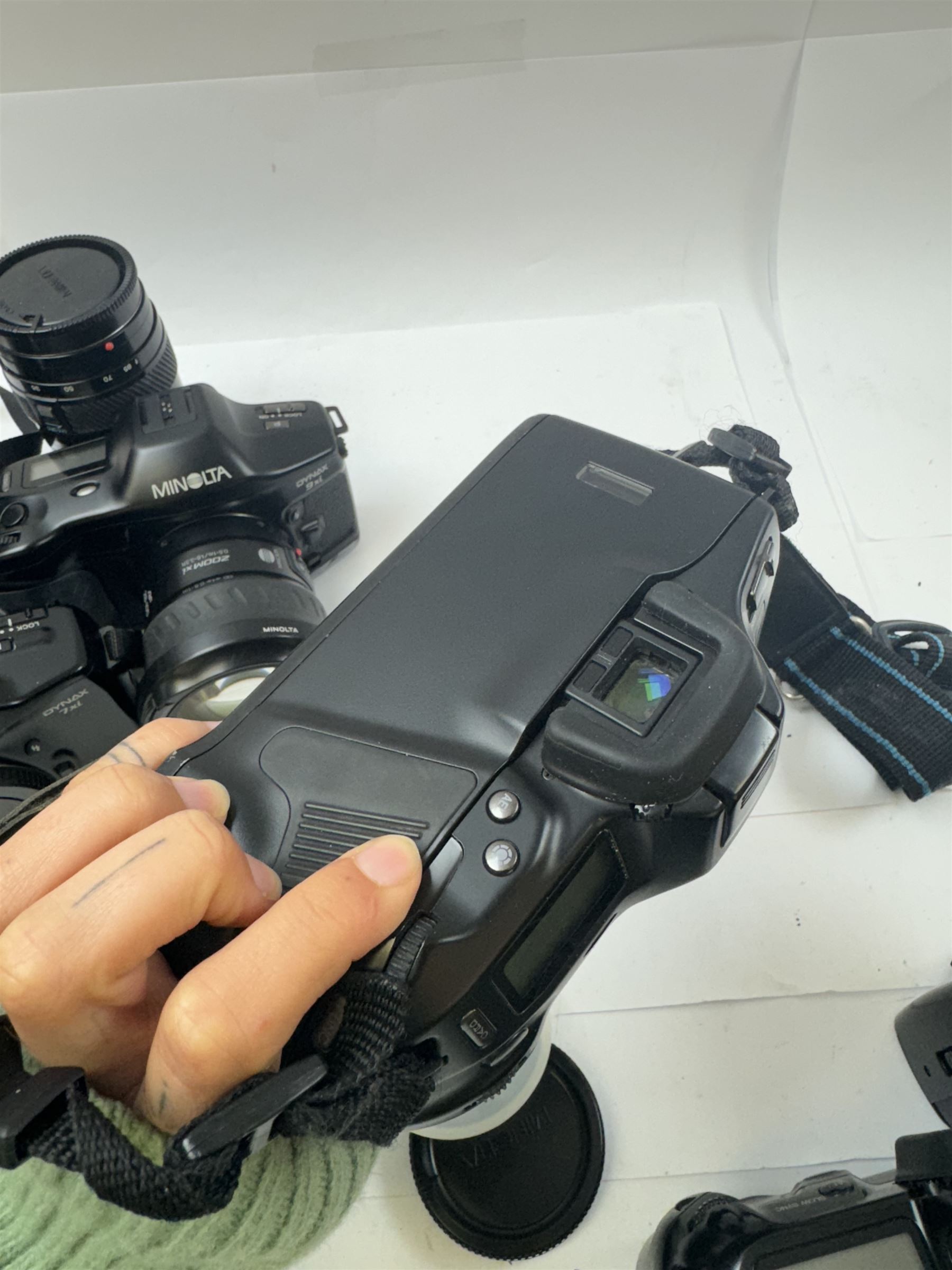 Six Minolta Dynax SLR camera bodies, comprising 800si serial no. 62703606, three 7xi examples, including one boxed example, serial nos. 20106944, 16123311 & 22107553, and two 9xi examples, serial no. 18209901 & 18202113, with three Minolta lenses, including Zoom xi 28-105mm 1:3.5(22)-4.5 lens, AF Zoom 28-85mm 1:3.5 (22)-4.5 lens and an AF Zoom 75-300mm 1:4.5(32)-5.6 lens, Hama carry case and other accessories