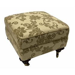 Floral upholstered footstool on brass castors