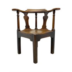 18th century oak corner elbow chair, the shaped cresting rail terminating to swept arm rests, supported by turned columns and vase-shaped splats, over square plank seat, raised on square-section supports