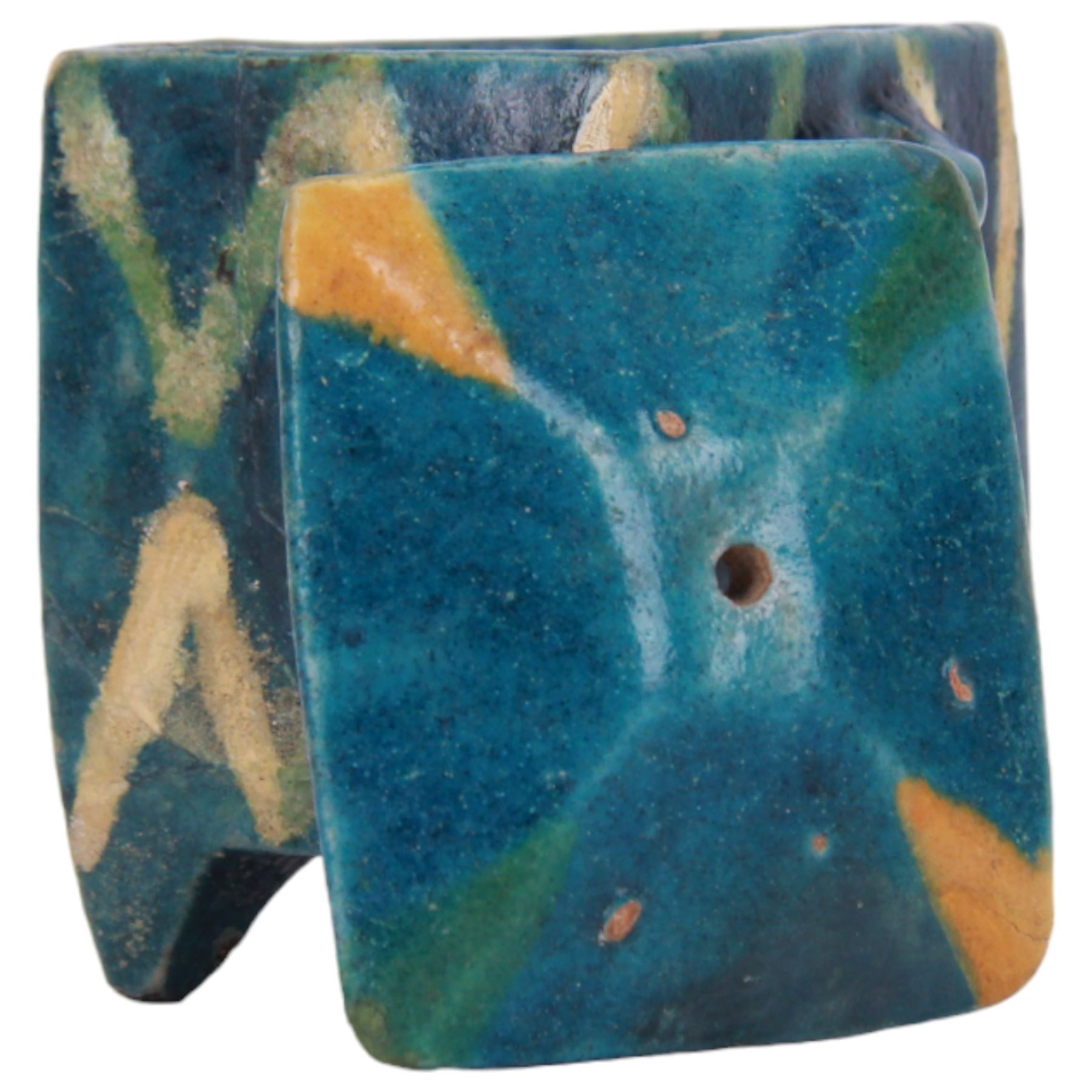 Raqqa ware pottery model of a monkey, probably Assyrian, modelled in crouching position, with turquoise and blue glaze, H6cm, together with a Raqqa ware pottery pot, also probably Assyrian, of square sided form, twin lug handles and canted cover, upon four tapering feet, decorated with yellow and green zig-zag bands upon a turquoise glazed ground, H8cm