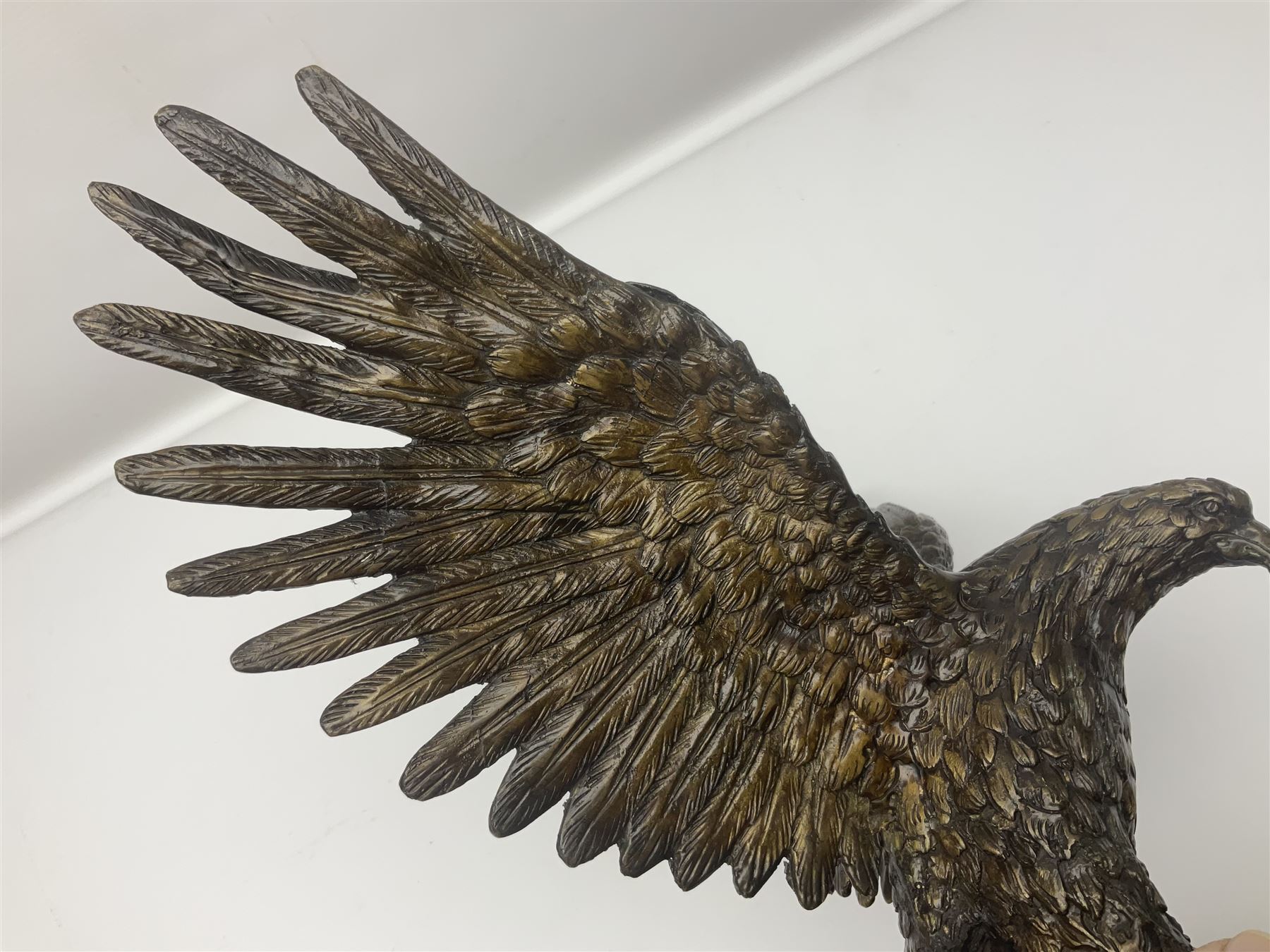 Bronze eagle, modelled in a standing position with wings spread, raised on a black veined marble circular plinth base, H29cm