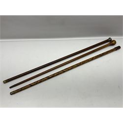 Three early 20th century walking sticks, to include a smoking pipe walking stick, the cane opening to reveal a concealed pipe, and a wooden walking cane, the metal cover with inscription 'bell metal and wood of York Minster, Burnt May 20 1840, and a turned wooden walking stick, with marquetry checkerboard pommel, tallest L90cm