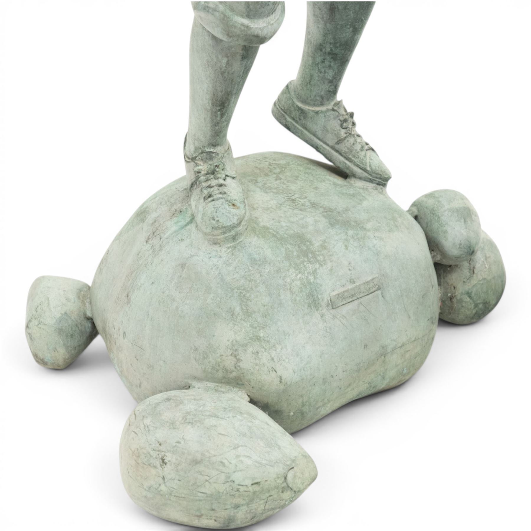 After Eneri Prosperi, bronze garden child statues, depicting children balancing on rock-form bases, the boy in shirt and shorts, the girl in dress with raised arms, surrounded by loose rounded pebble elements