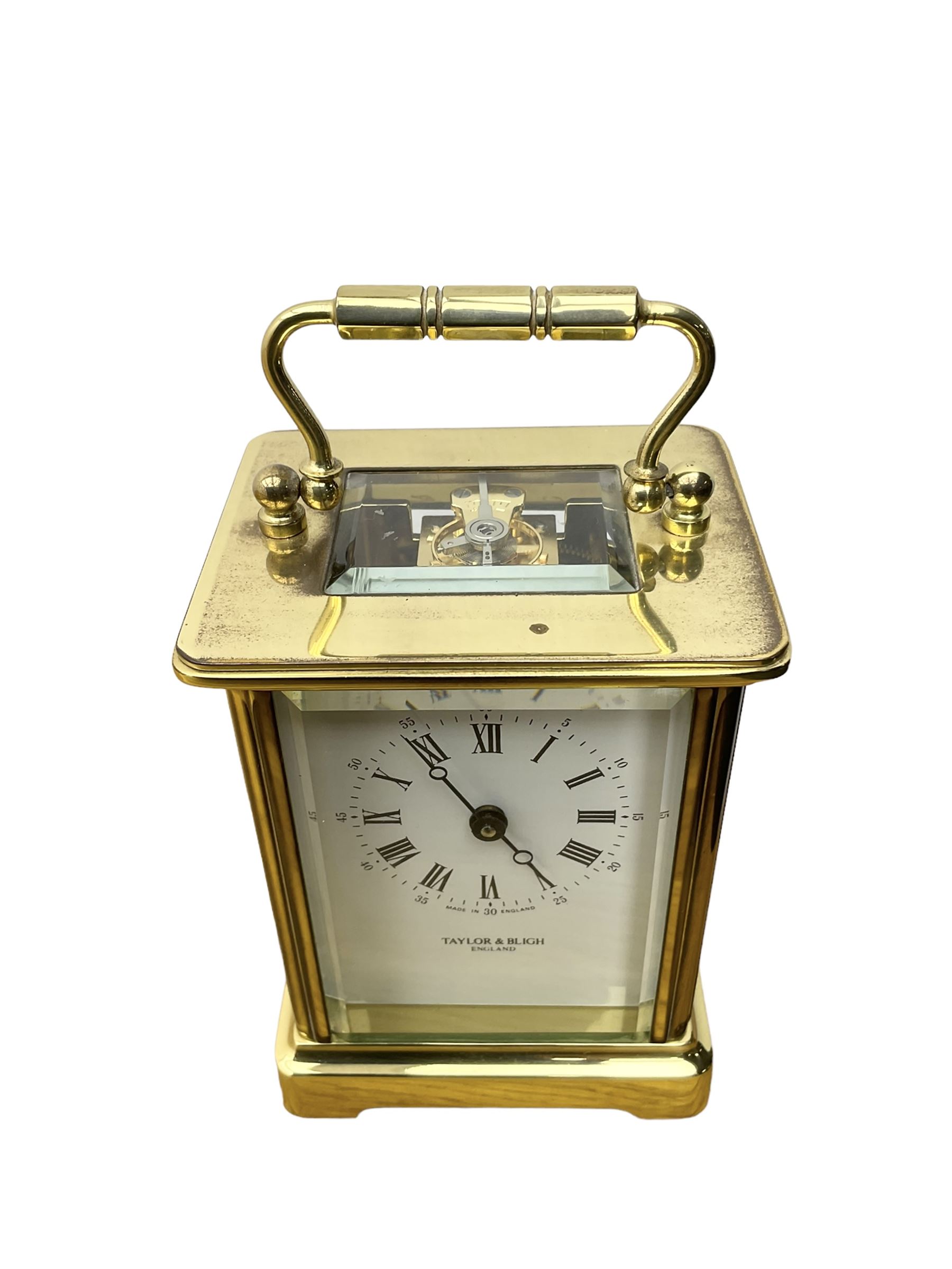 Taylor & Bligh - English 8-day carriage clock in a corniche-style case, white dial with roman numerals and steel moon hands, 11 jewel movement with a lever platform escapement. With key.