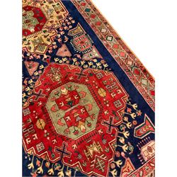 Persian Heriz Kelleh runner, the blue ground field with three large medallions and decorated with stylised plant motifs, triple border decorated with stylised flower head motifs
