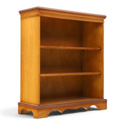 Contemporary mahogany and yew wood open bookcase, dentil cornice above two adjustable shelves, shaped apron and bracket feet 