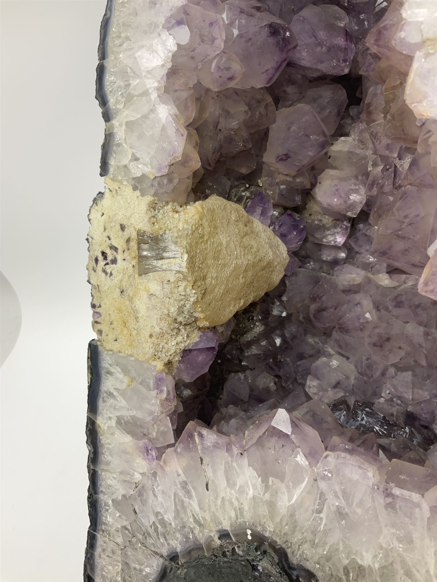 Amethyst crystal ‘cathedral’ geode, free standing with flat base and prepared outer surface, with well-defined crystals of various sizes within the cavern, H39, L32cm