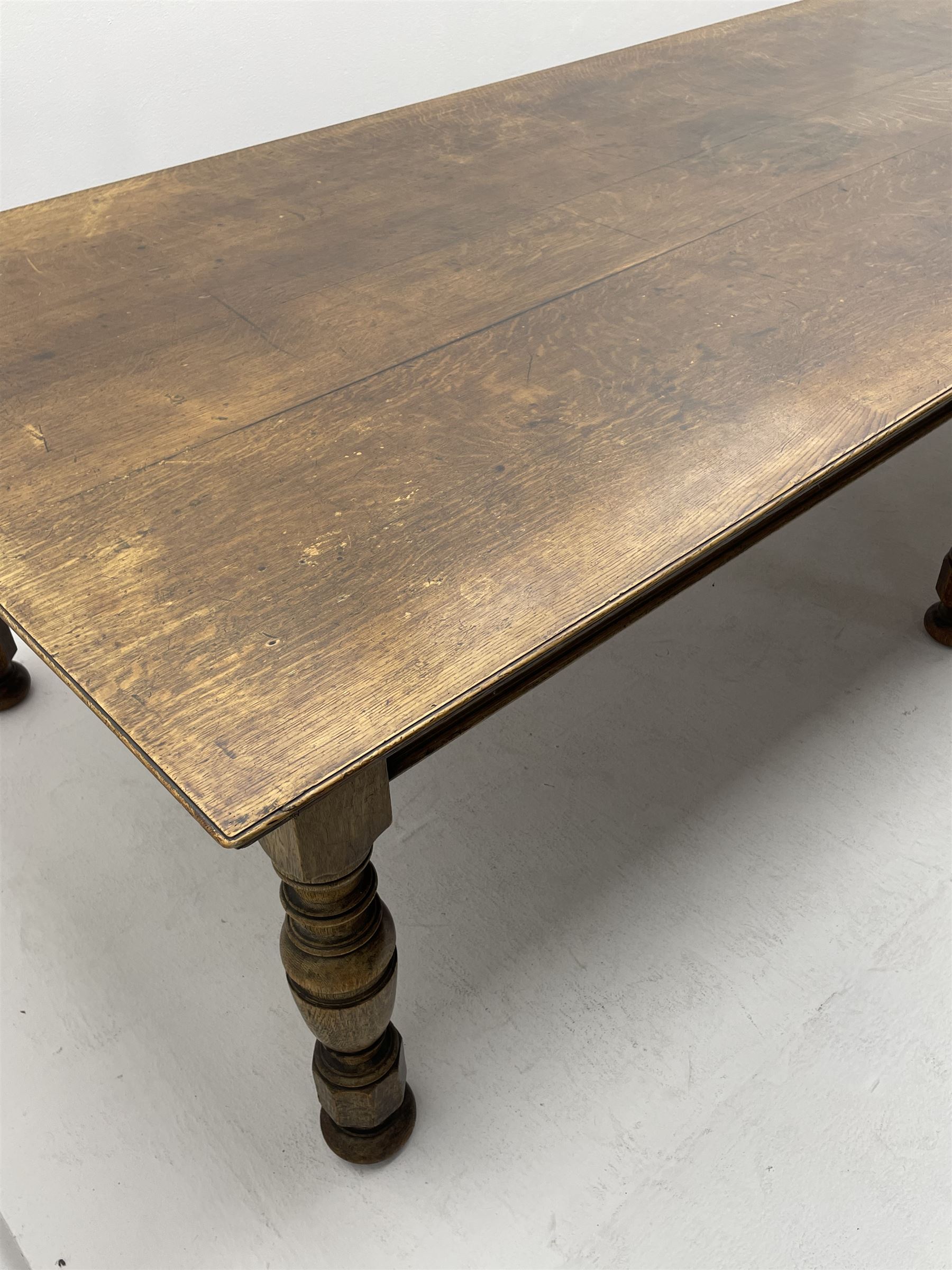 Large early 20th century oak boardroom table, rectangular moulded top on six turned and faceted supports 