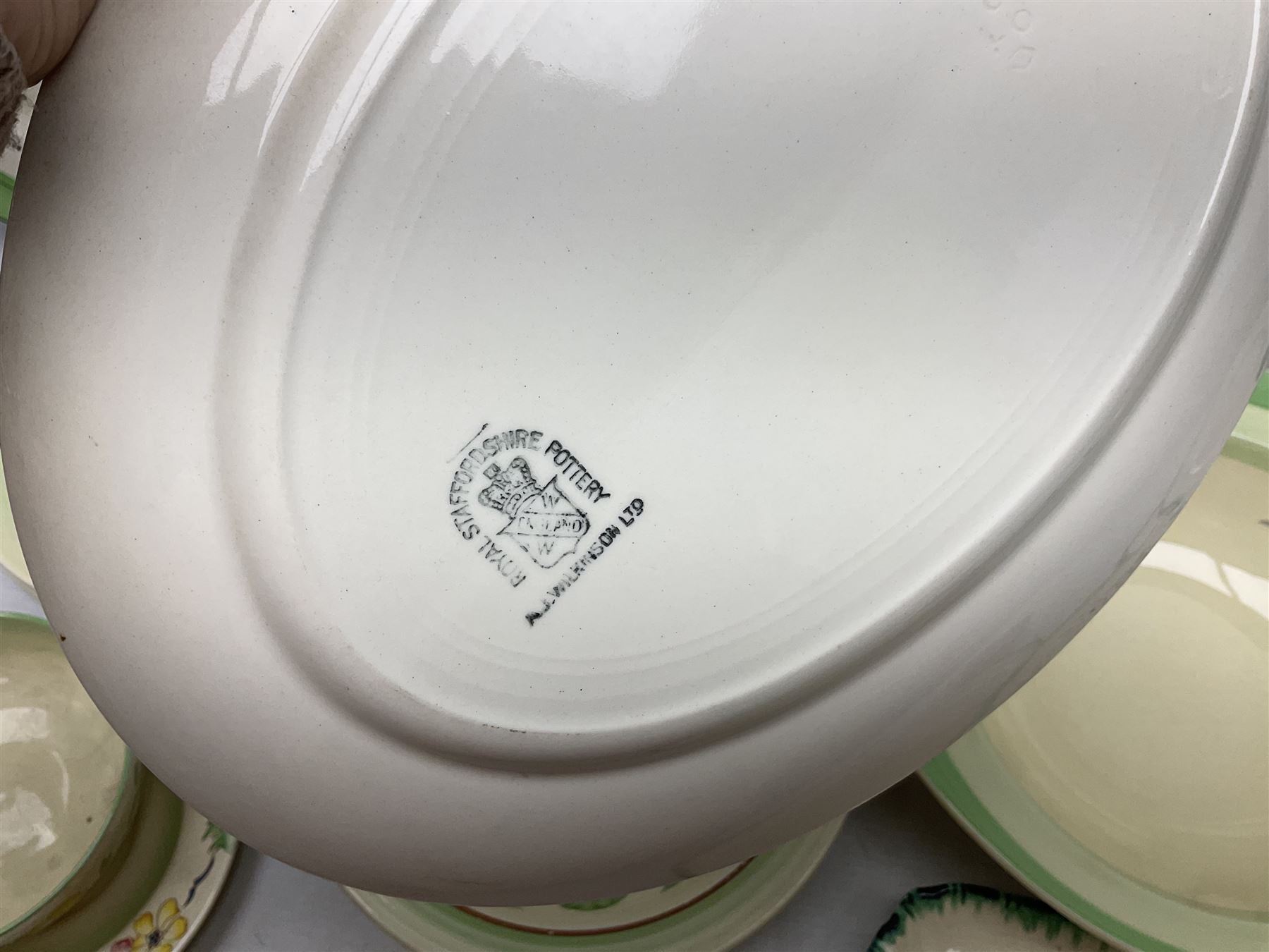 Clarice Cliff for Newport Pottery Corolla pattern tea and dinner wares, comprising triangular bowl, four side plates, two shallow bowls and teacup (a/f), together with a Clarice Cliff Wilkinson twin handled soup bowl and unassociated saucer both decorated with pink and yellow flowers, together with other mid century ceramics comprising Parrott and Company Coronet Ware, and Royal Staffordshire AJ. Wilkinson Ltd dinner wares