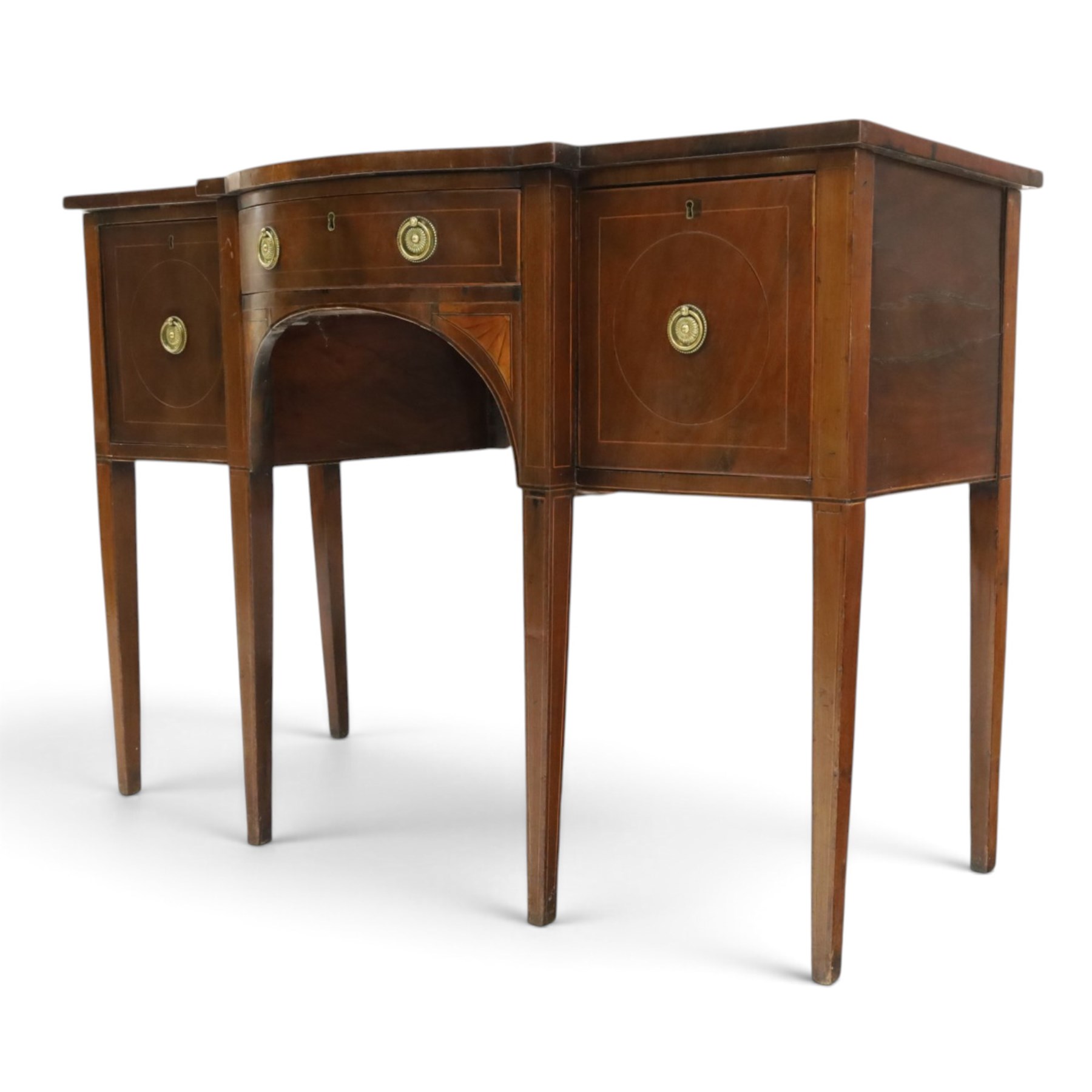 Regency period inlaid mahogany bow-breakfront sideboard, shaped rectangular top with crossbanding and ebony stringing, central convex frieze drawer flanked by cupboard and cellarette drawer, over fan-inlaid spandrels, raised on square tapering supports