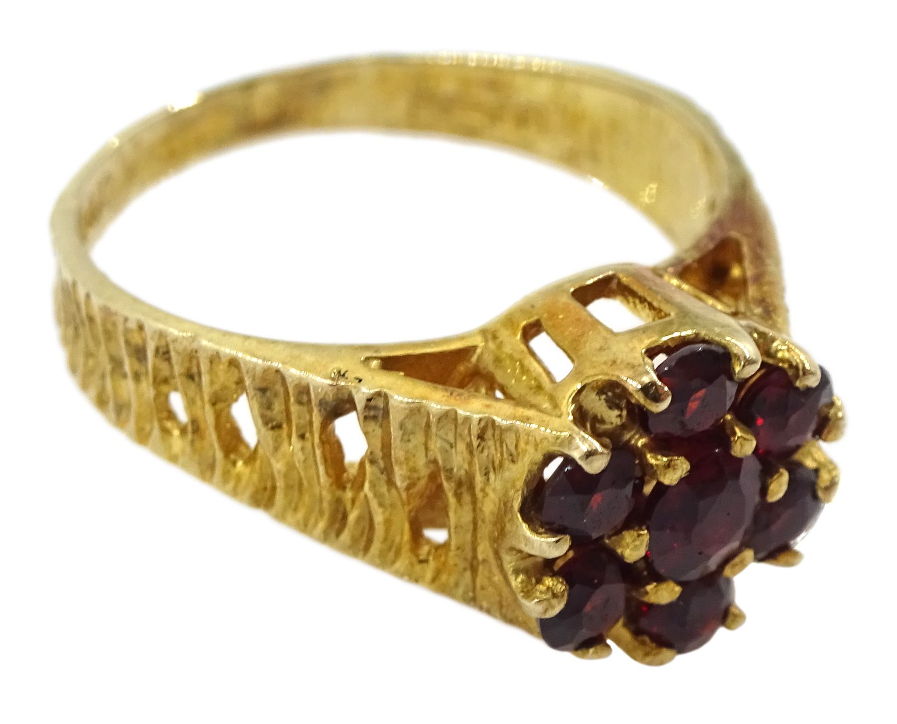 9ct gold garnet flower head cluster ring, with textured and pierced shoulders by Slade & Kempton, London 1978