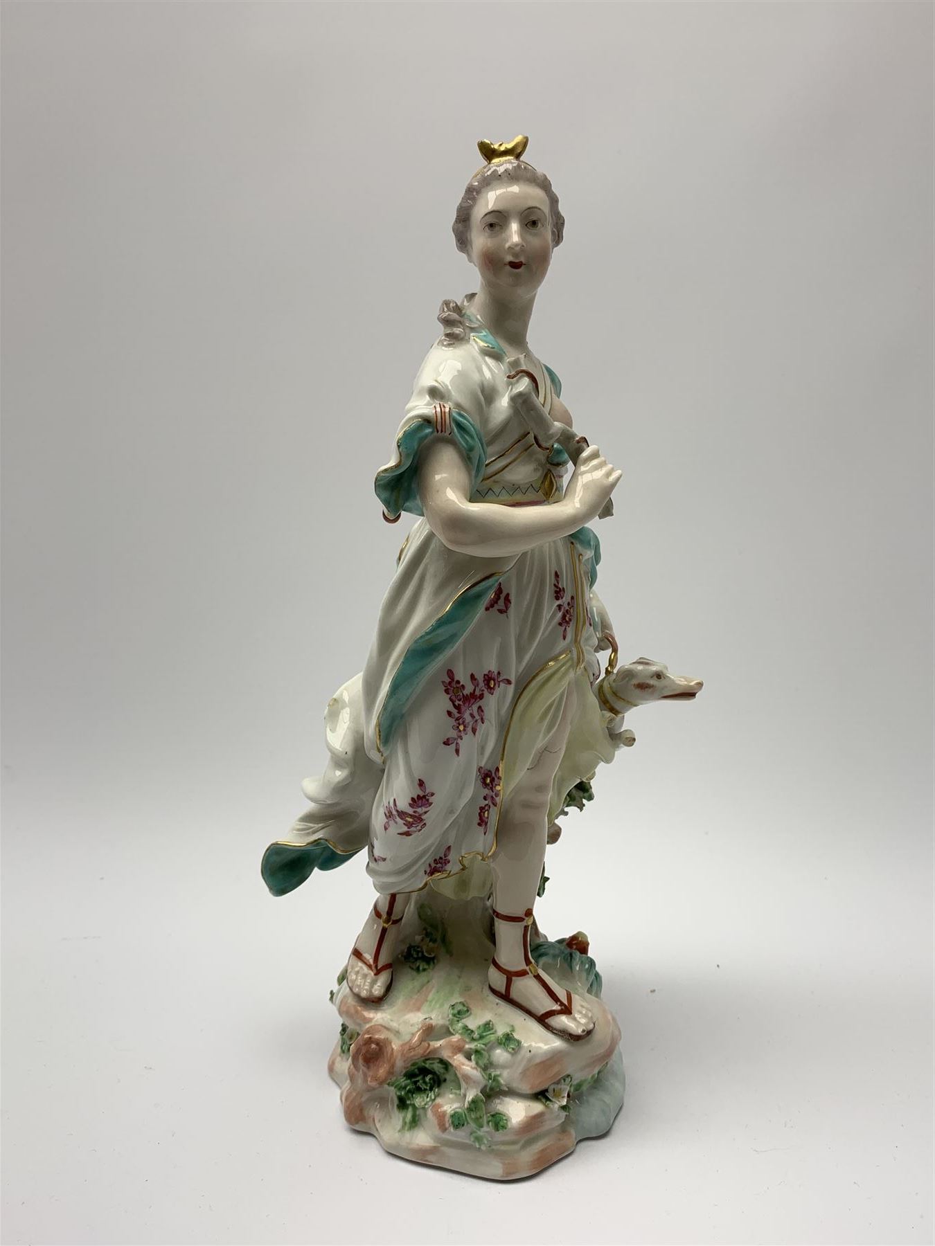 Mid 18th century Derby porcelain figure modelled as Dianna the Huntress, with quiver of arrows upon her back and dog by her side, upon a naturalistically modelled base, with patch marks beneath and collectors labels, H26cm