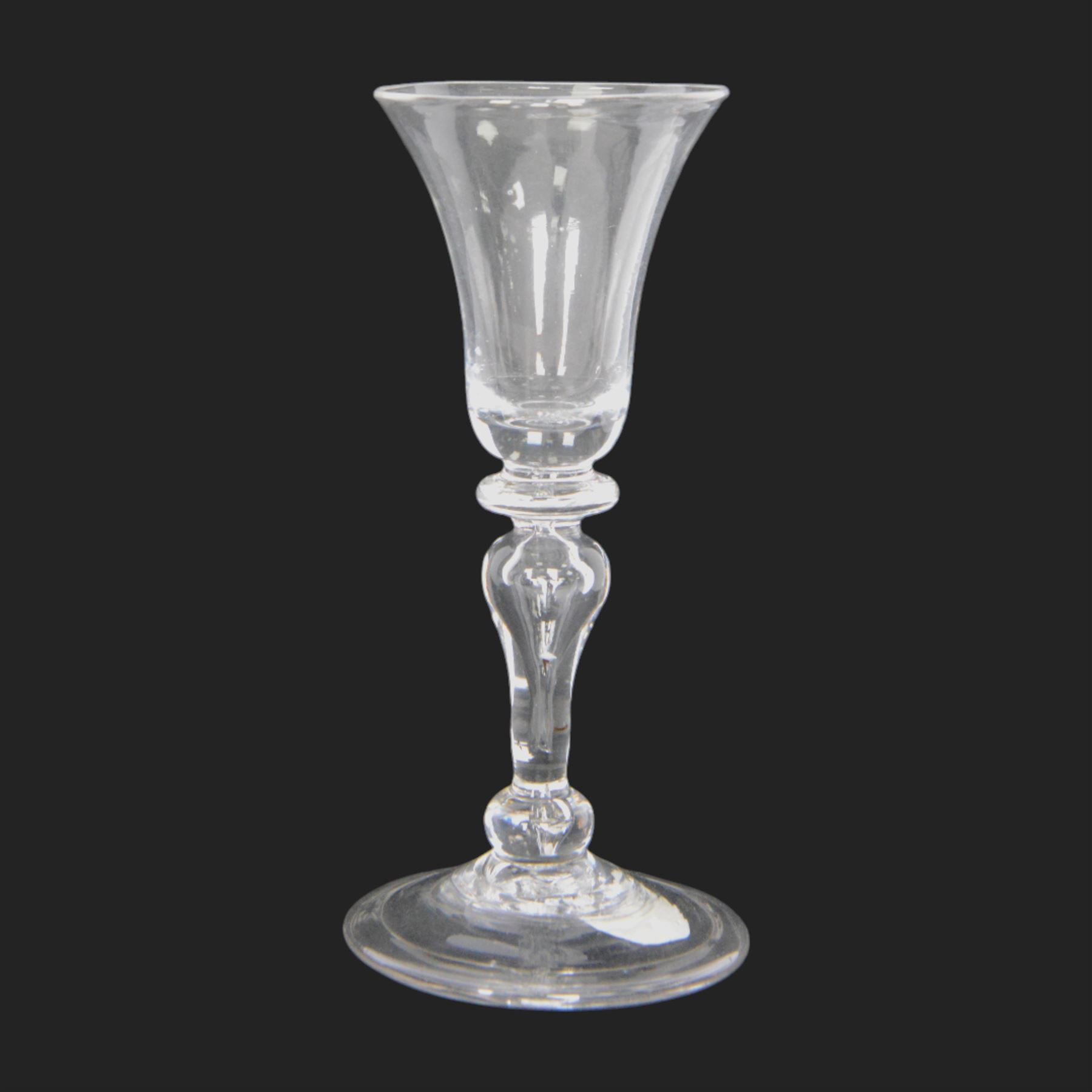 Mid 18th century wine glass, circa 1730-1740, with bell shaped bowl upon an inverted baluster stem with internal tear and basal knop, upon conical folded foot, H15cm