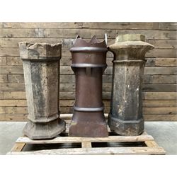 Collection of three Victorian and early 20th century reclaimed terracotta chimney pots, comprising: one cylindrical form with weathered, cracked glaze and flared octagonal base; one deep red cylindrical pot with fluted midsection and castellated rim, bearing moulded number ‘25’; and one tapering hexagonal example with wide flared rim and weathered patina. All with age-related wear and chips, consistent with use and outdoor exposure. Plus a selection of cast stone pieces including fountain 
