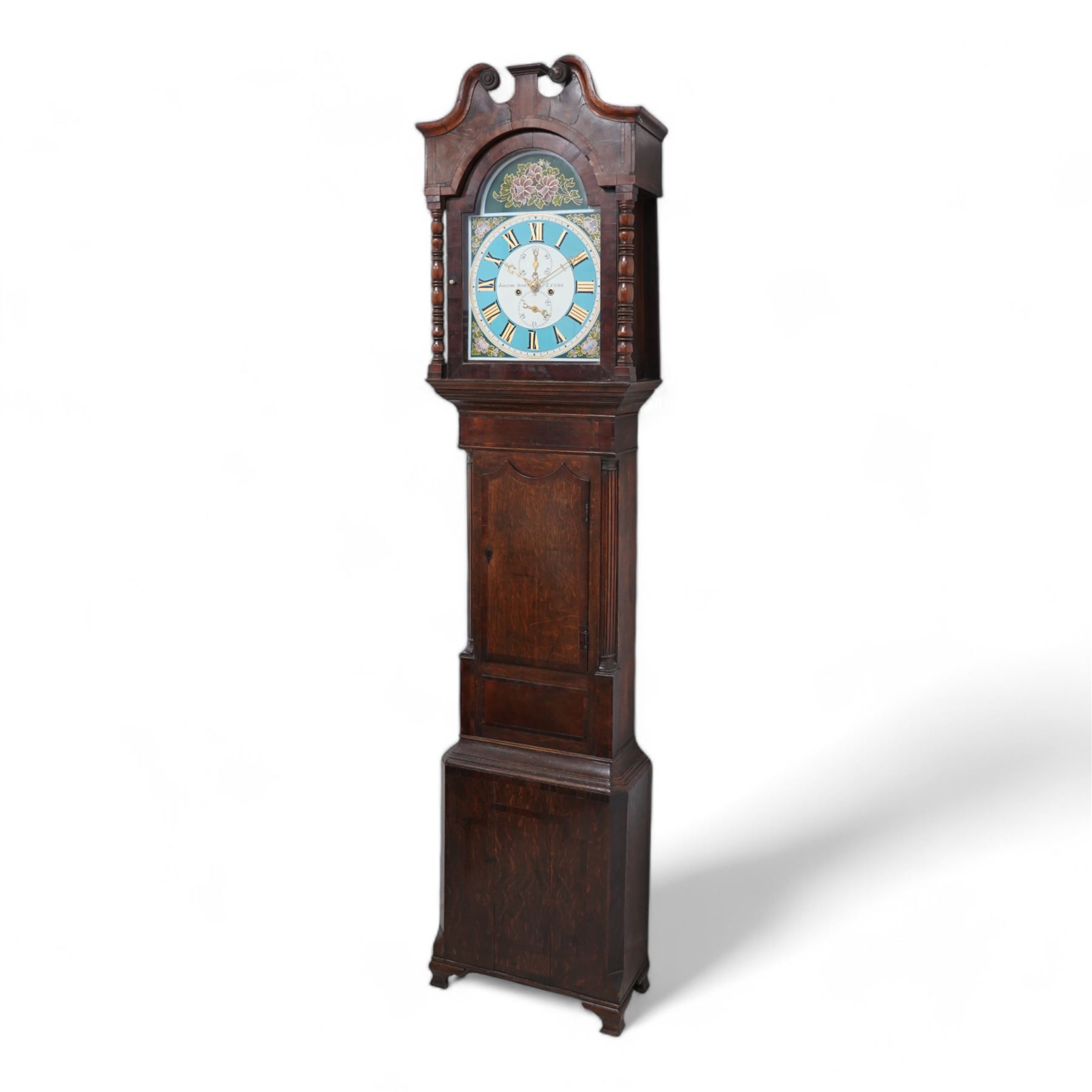 Joseph Scott of Leeds - 8-day oak and mahogany longcase clock c1865, with a swan necked pediment and wooden parterre, break arch hood door flanked by spindle turned pilasters, trunk with reeded quartered columns and a short door with a double spire top, on a deep plinth with crossbanding and raised on bracket feet, painted dial with gold 