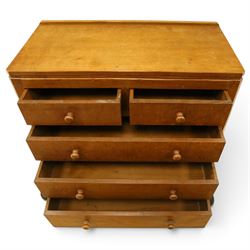 Mouseman - early-to-mid 20th century adzed and panelled oak chest, raised back over rectangular adzed top with canted corners, fitted with two short over three long drawers with turned knob handles, raised on octagonal feet, with carved mouse signature, by the workshop of Robert Thompson of Kilburn