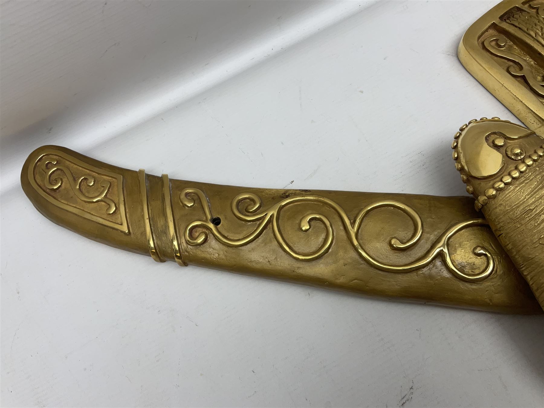 Gilt state emblem for Oman, a sheathed khanjar dagger superimposed above pair of crossed swords and belt and a seperate crown, main emblem H84cm, W83cm, crown H35cm, W33cm
Provenance by vendor repute: The emblem was previous mounted above HM's throne, in the main majalis, of the HM Royal Yacht AL Said, until 1985 when HM Sultan Qaboos ordered the upgrading of all state emblems, The emblem was gifted to the vendor who worked for the Sultans Royal Yacht Squadron
