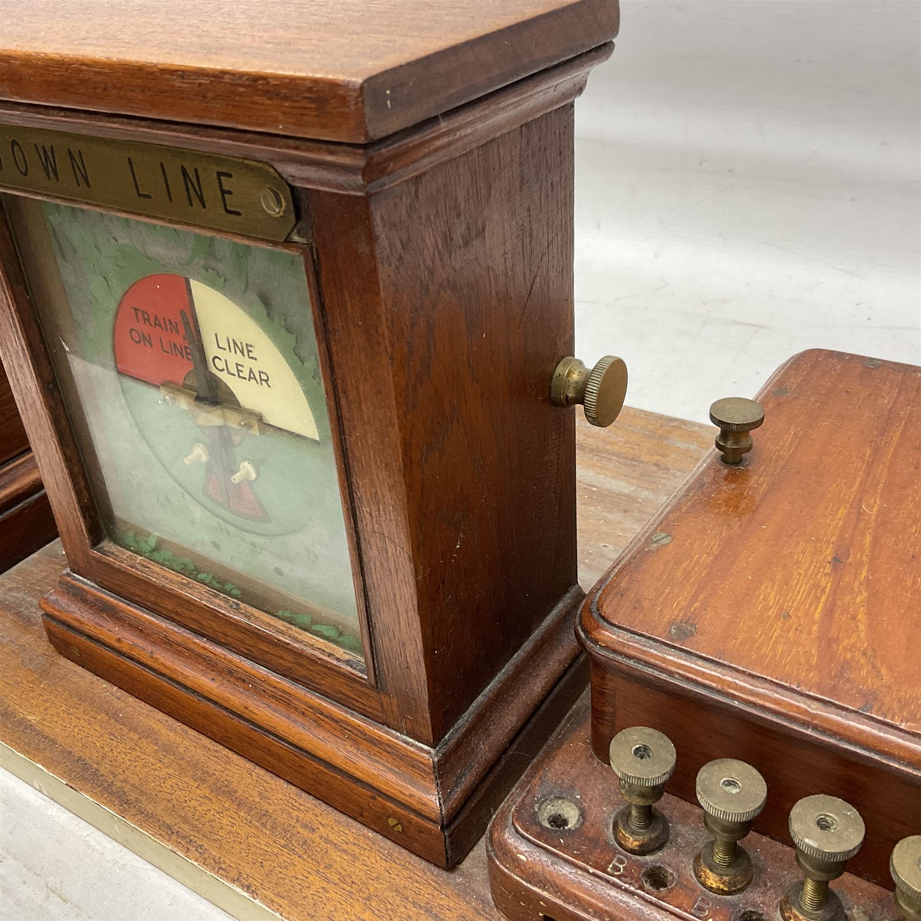 Railway signal boxes, mounted on plinth, with railway block indicators for Up Line and Down Line, having an electromagnetic indicator showing 'Train on Line' 'Line Clear' and 'Line Blocked', and brass signal bell to the centre, L100cm