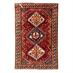 South West Persian Cori hand-knotted rug, red field with three central stepped lozenge med...