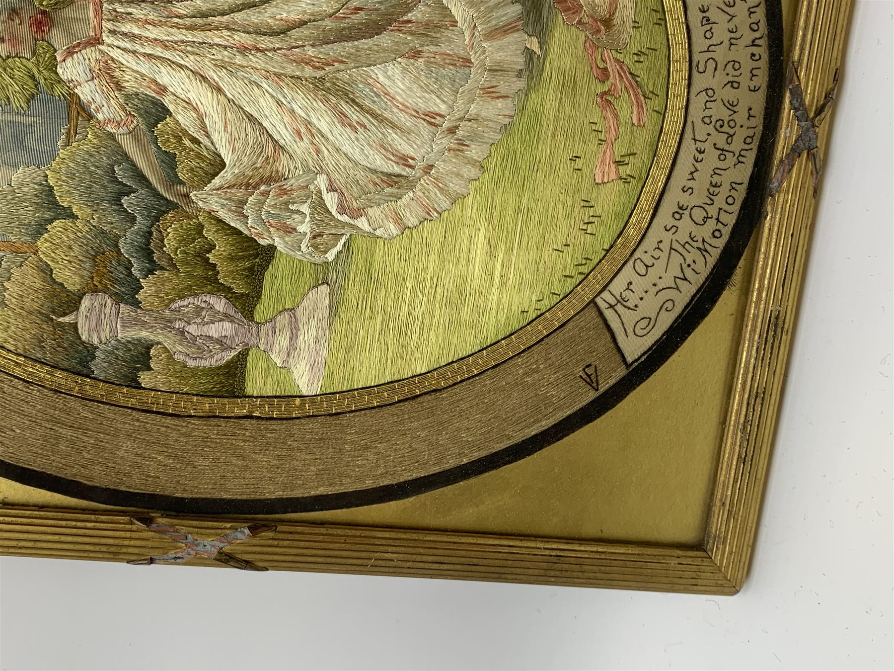 George III silkwork picture, of oval form depicting a female figure in garden setting, within a silkwork border detailed with verse from Robert Burns Bonnie Peg, 'Her air sae sweet, and shape complete, The Queen of Love did never move, Wi' Motion mair enchanting!', and monograms 'FV' and 'SM', in reeded gilt frame and gilt mount, indistinctly inscribed in pencil verso, overall H36cm L30.5cm