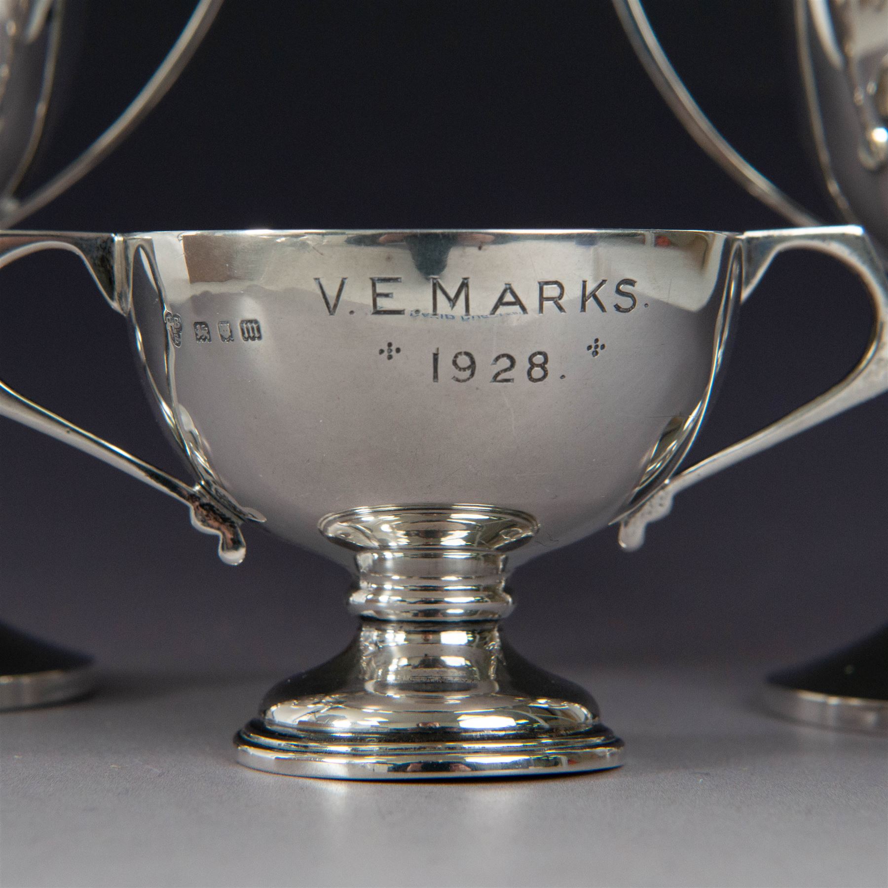 Pair of 1930s silver trophies, with angular handles and presentation engravings to body, hallmarked William Hair Haseler, Birmingham 1938, together with a similar smaller example, hallmarked Charles Boyton & Son Ltd,  London 1927, tallest H13cm