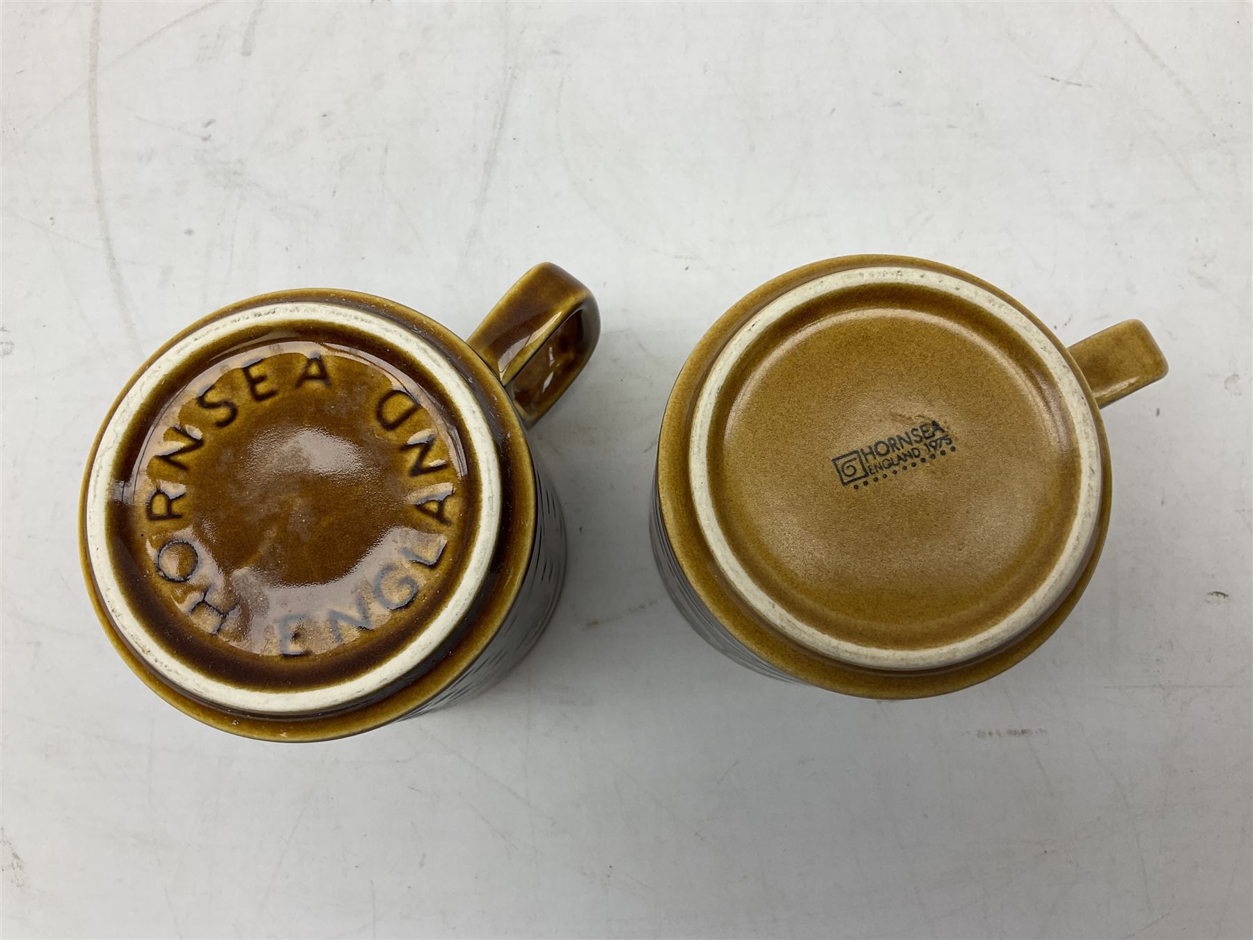 Collection of 1970s Hornsea mugs designed by John Clappison, comprising six Train Robber pattern examples together with owl patterned example on dark teal ground, and further example decorated with stylised hen and chick and egg, approx 9cm, together with four small cup bowls, all with stamped Hornsea marks beneath