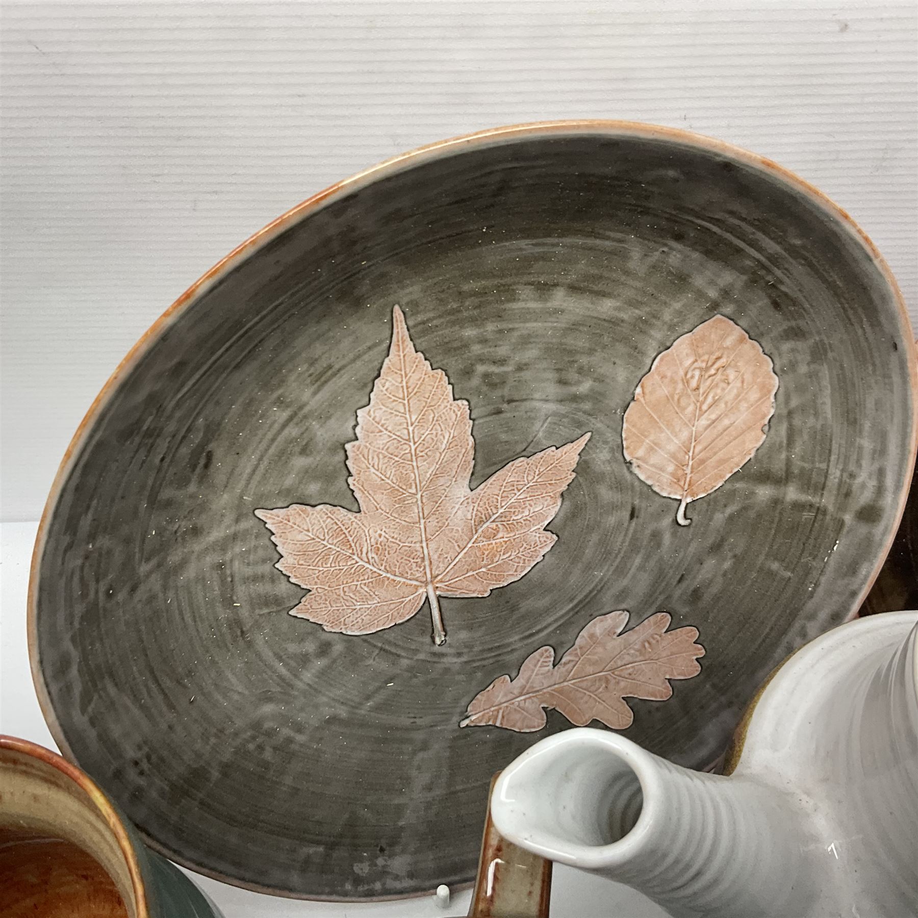 Wold studio pottery tankards, in various colours and relief decoration together with other studio items including vases, jugs and pots 