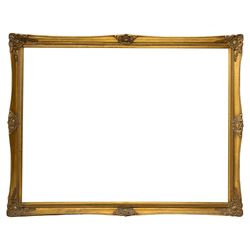 Large swept gilt-framed mirror, decorated with scrolled foliate cartouches and moulded inner slip, bevelled glass plate