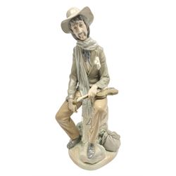 Lladro figure, Violinist, modelled as a man seated upon a  mile stone holding a violin, sculpted by Salvador Furió, no 4887,  year issued 1984, year retired 1981, H35cm