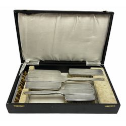 Cased silver mounted dressing table set, comprising hand held mirror, hair brush, and clothes brush, hallmarked Walker & Hall, Chester 1939/1940, Sheffield 1939. 