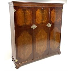Edwardian mahogany inlaid and cross banded triple wardrobe, projecting cornice above linen slides above two drawers, bevel edge mirror and fitted interior, brass hinge and handles, shell carved shaped bracket supports