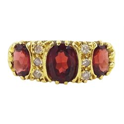 18ct gold three stone oval cut garnet and six stone, round brilliant cut diamond ring, London 1966