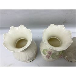 Five late 19th/early 20th century and later Belleek vases, comprising pair of Lotus Blossom examples, shamrock tree trunk vase, twin handled shamrock vase and a baluster form vase decorated with applied roses, all with printed marks beneath, tallest H16cm