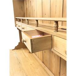 Waxed pine dresser with plate stand, projecting cornice, two shelves above six short drawers, dresser is complete with six drawers and single opening cupboard, turned supports 