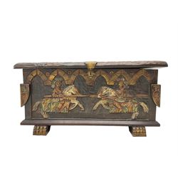 Carved wooden blanket chest, the tooled hinged lid with shaped metal strap hinges and catch, the front carved with arcade over two medieval jousters, on carved sledge feet