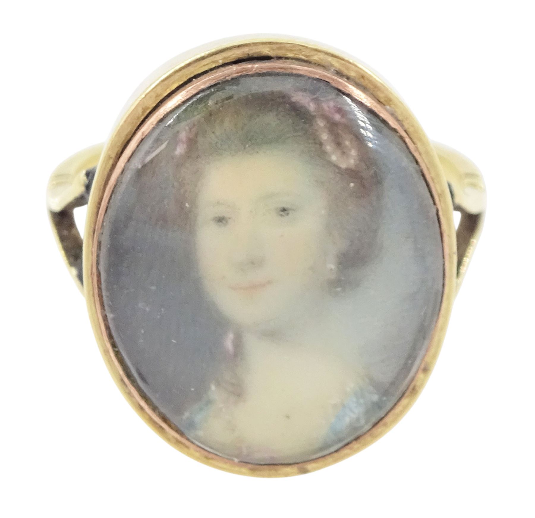 19th century gold portrait ring, set with an oval miniature of a woman wearing a pearl hairpin and earrings on ivory, under a glazed panel, set into a later gold ring with split shoulders. This lot has been registered for sale under Section 10 of the APHA Ivory Act