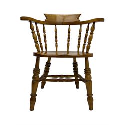 Late 19th century elm smoker’s bow armchair, curved top rails over turned spindle backs, shaped seats, raised on turned legs united by turned stretchers; together with a similar smoker’s bow armchair (2)