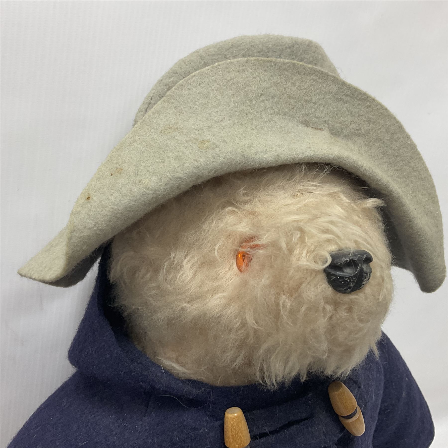 Pair of Paddington Bear teddies with amber eyes, the first example having a brown felt hat, red coat and blue PB boots with original label; the second having a grey felt hat, blue coat and blue Dunlop boots, tallest H51cm 