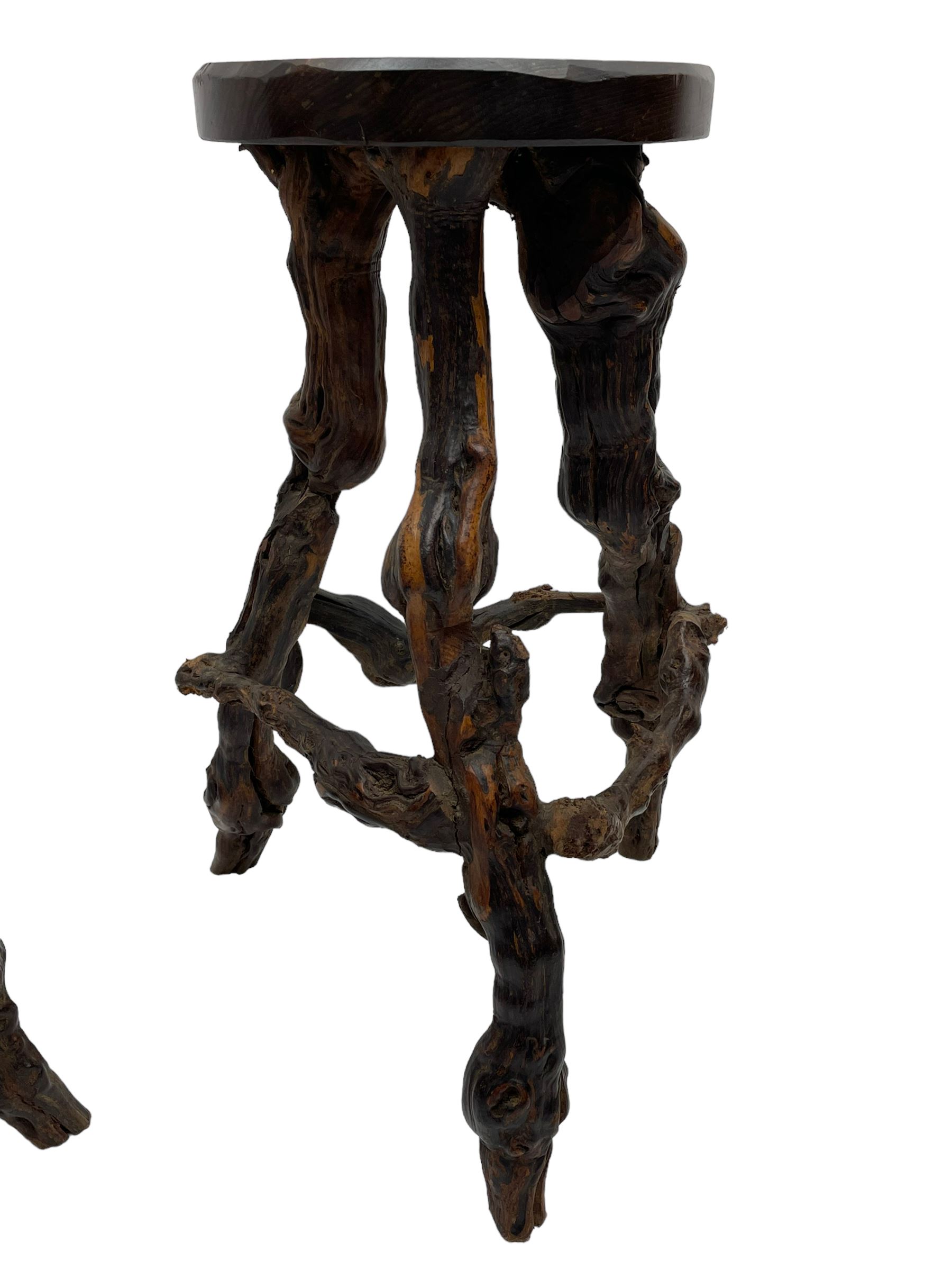 Mid-20th century French grapevine and walnut bow-front wine tasting bar, the curved counter top supported by sculptural grapevine roots, fitted with single shelf and raised on rustic vine feet (W100cm H101cm); with a pair of matching bar stools, the circular top raised on three gnarled root supports united by stretchers (W50cm H70cm)