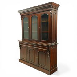 Victorian revival hardwood dresser, projecting moulded cornice above three glazed doors enclosing shelves, moulded top over three drawers and three panelled cupboard doors, flanked by applied carved scroll brackets, on plinth base,
