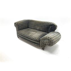 Early 20th century two seater drop arm sofa, upholstered in geometric pattern, turned supports and castors 