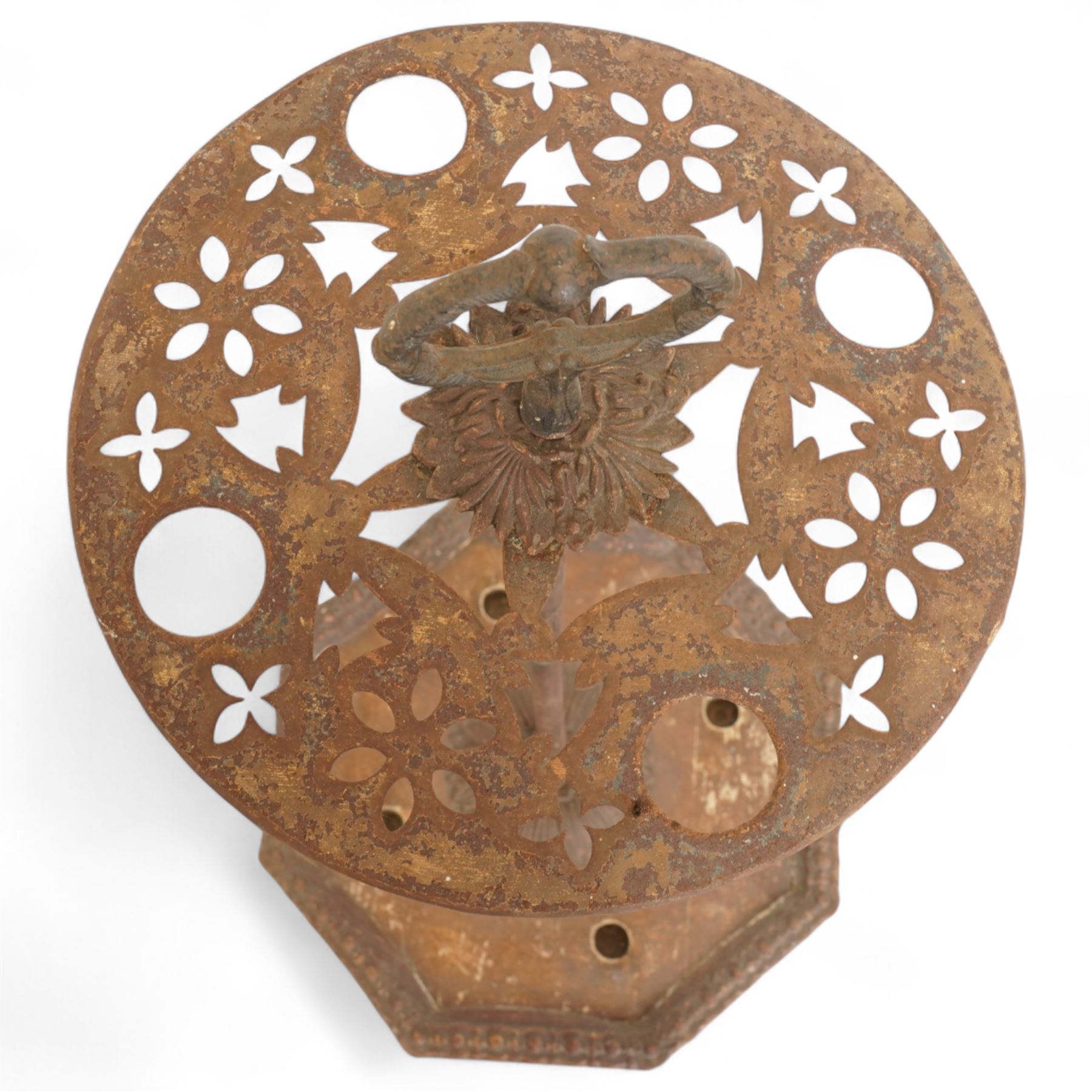 Victorian cast iron cane or stick stand, the top with a large loop lifting handle and floral design above geometric pierced decoration, central vertical rod, and octagonal base with lion paw feet